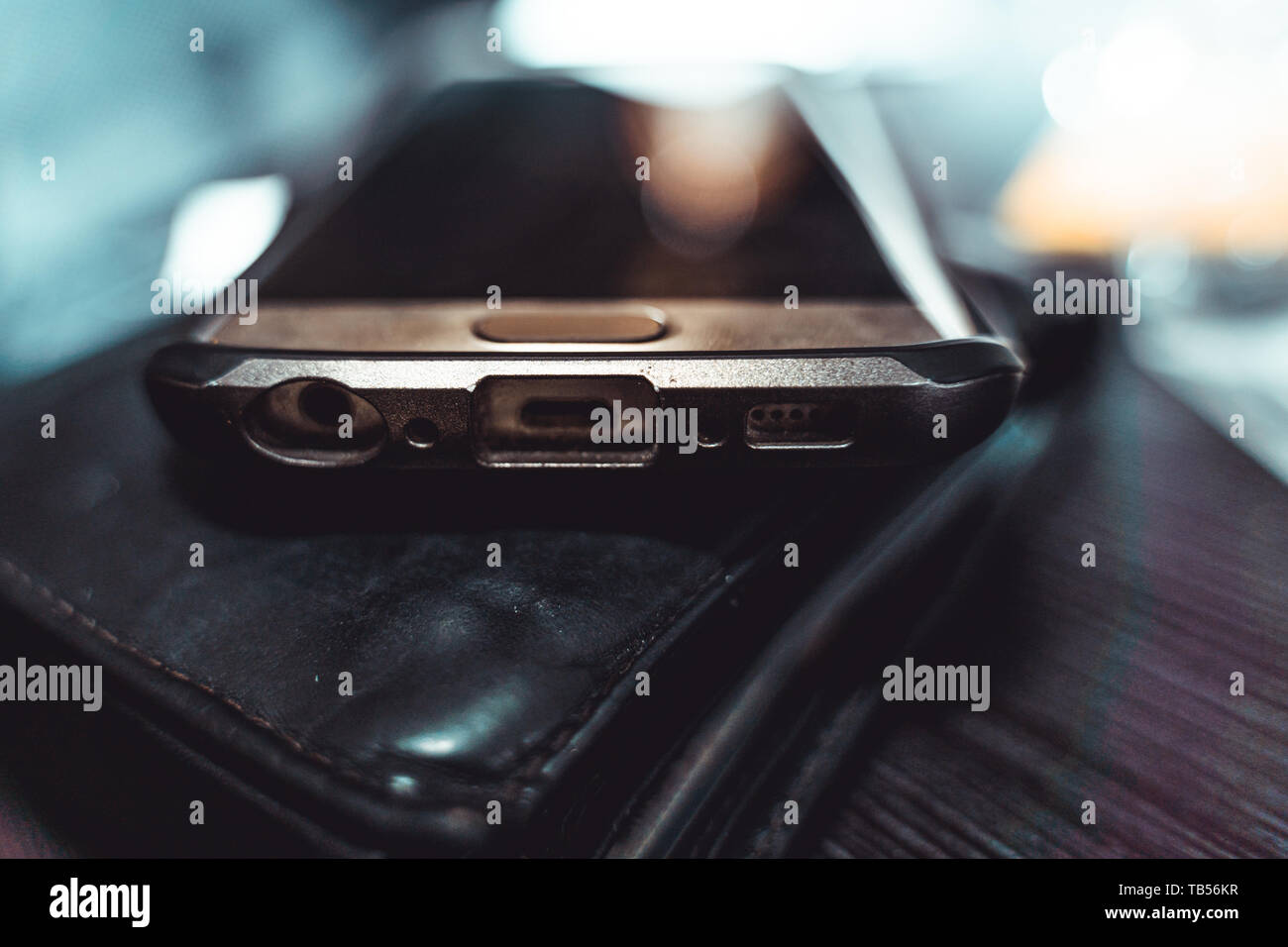 Il telefono cellulare si trova su un portamonete su un tavolo. (Luce indiretta) Foto Stock