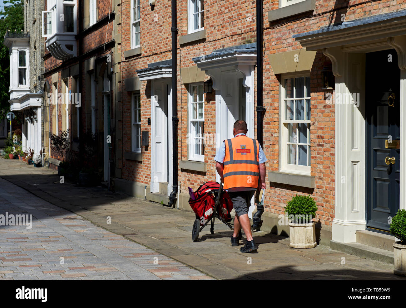 Portalettere sul suo giro di recapito di Howden, East Yorkshire, Inghilterra, Regno Unito Foto Stock