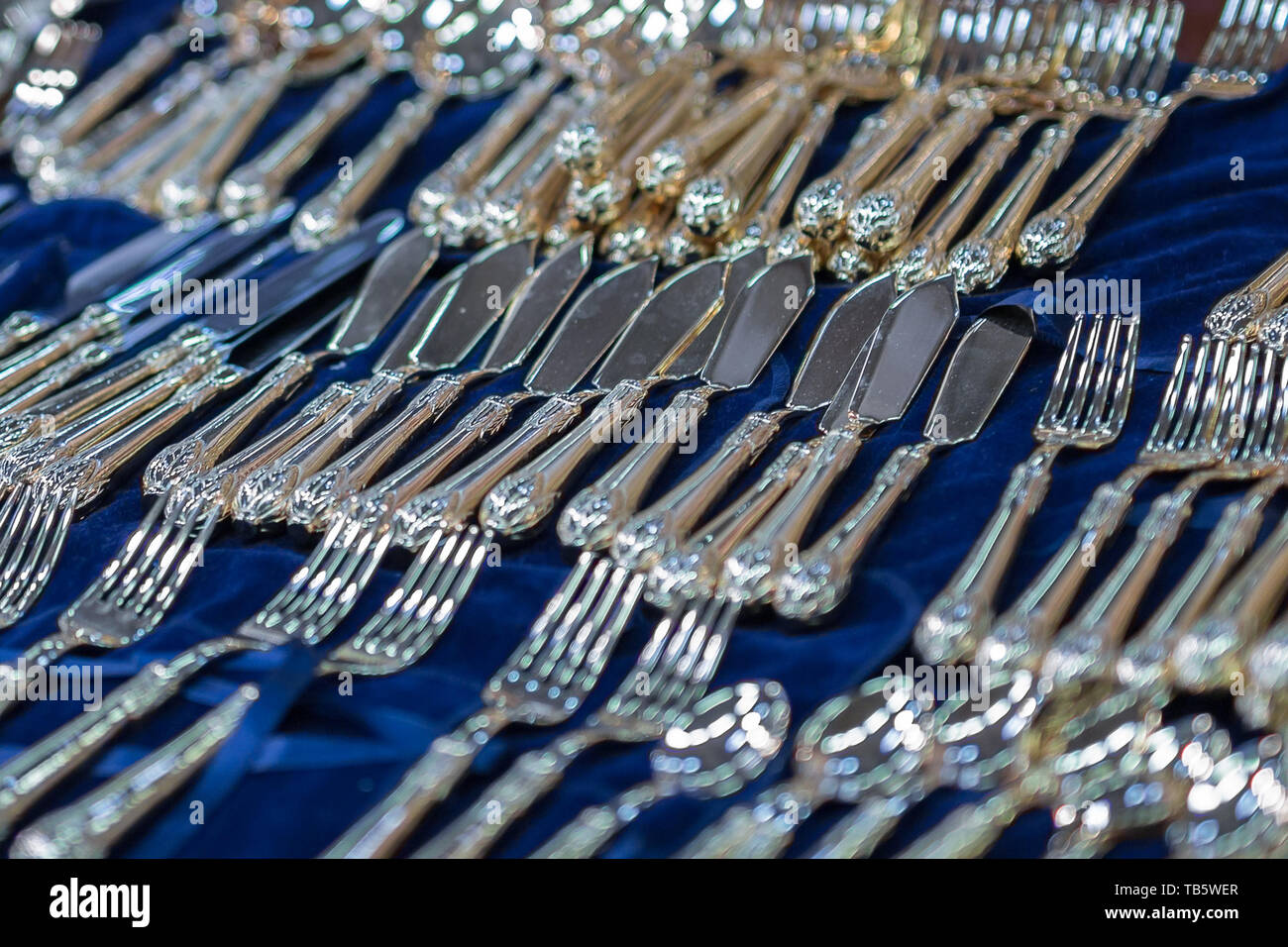Argento Cucchiai e forchette giacente su una tovaglia blu: argenteria. Foto Stock