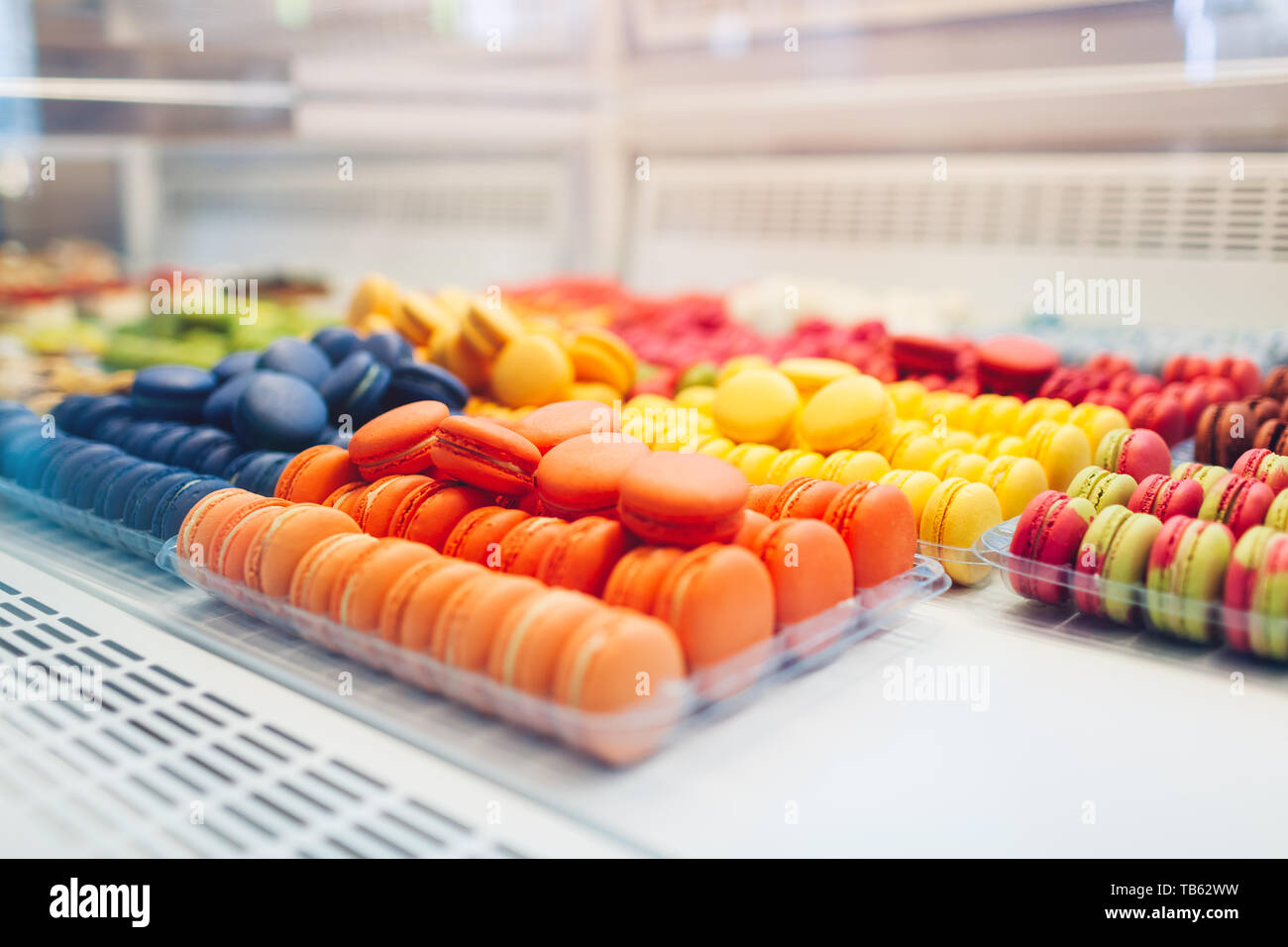 Assortimento di amaretti colorati su cafe vetrina. Varietà di sapori macaron. Dolce dolci di mandorla in negozio. Biscotti francesi. Foto Stock