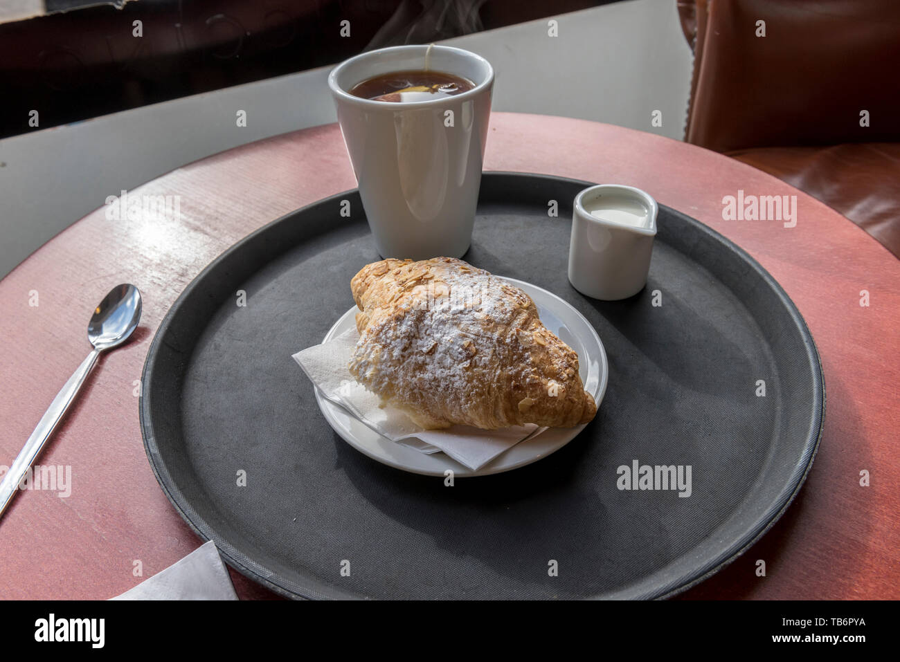 L'unica altra cosa di cui avete bisogno con il tuo croissant è una tazza grande di caffè Foto Stock