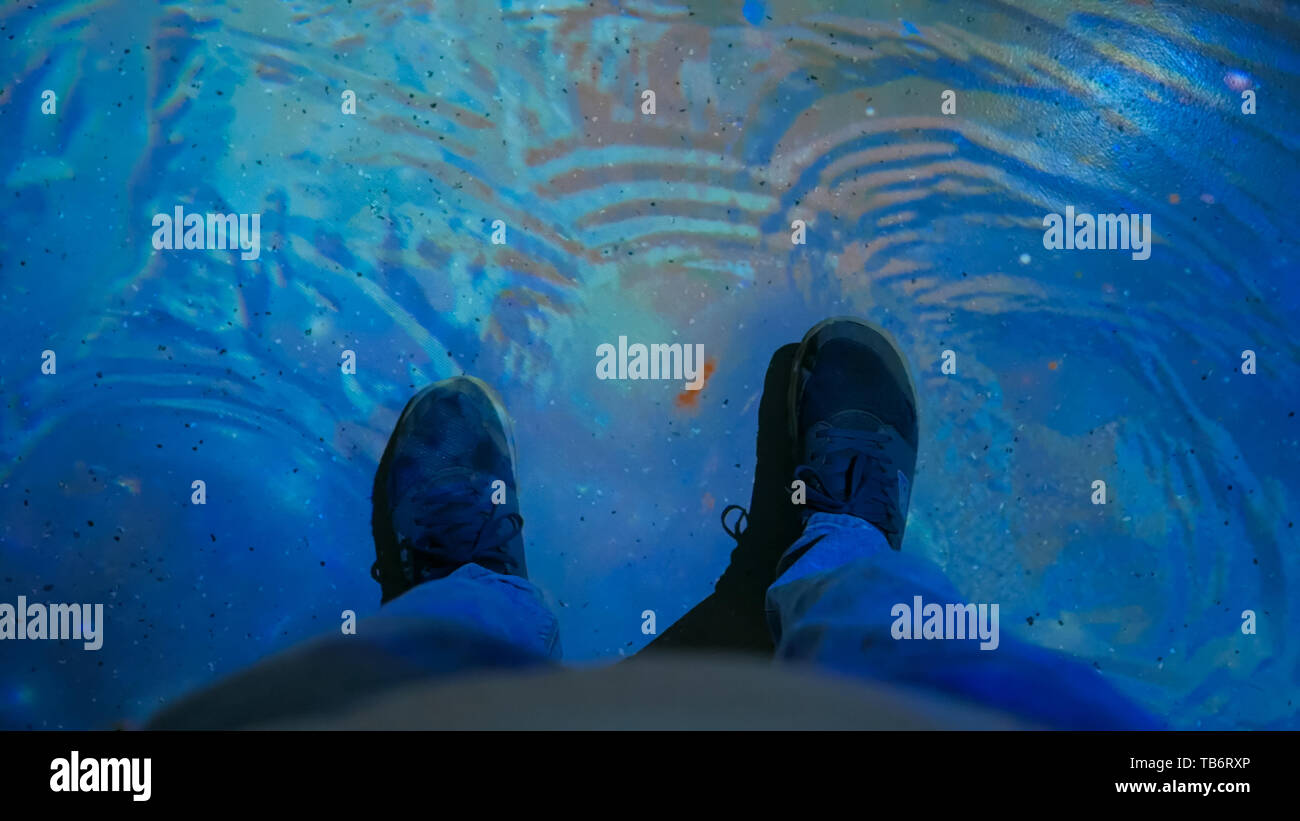 Uomo che cammina su interactive superficie di acqua Foto Stock