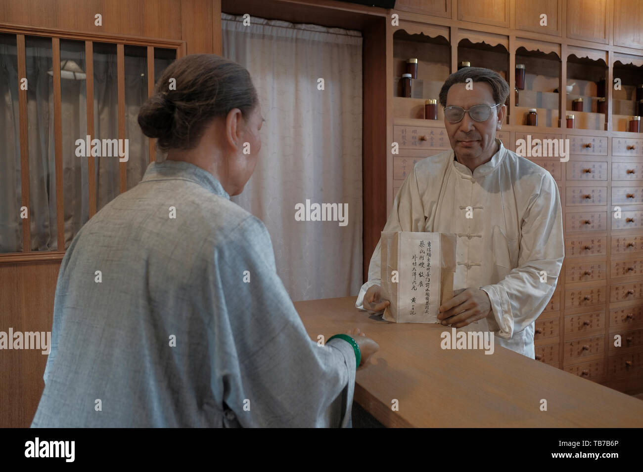 I manichini a grandezza naturale illustrano un farmacista e un cliente in una farmacia presso l'ex scuola elementare Jinshui, ora un museo costruito nel 1932 sulla base del progetto di un'accademia cinese tradizionale nel quartiere Jinshui, Jincheng Township, Kinmen Island Taiwan Foto Stock