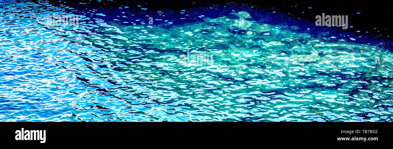 Foto orizzontale di acqua in blu, colore turchese con luce solare riflettente. Foto Stock