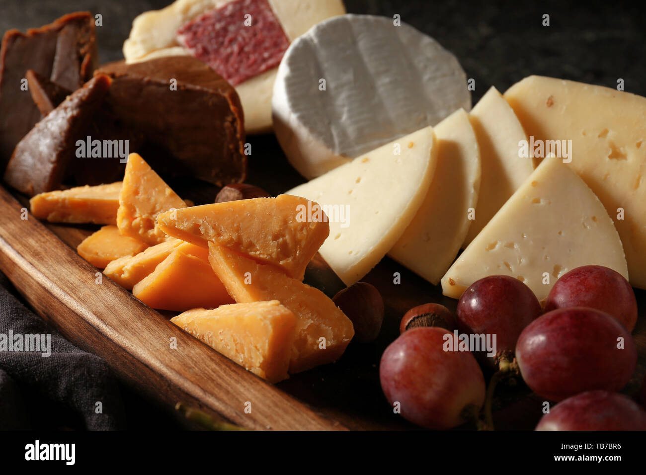Assortimento di formaggi saporiti su pannello di legno Foto Stock