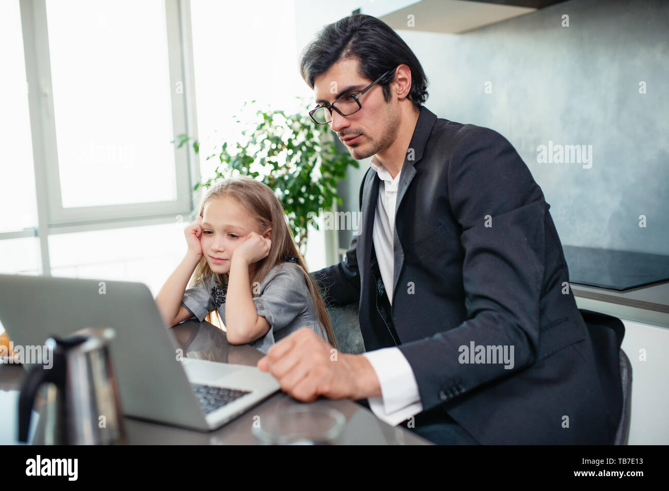 Felice bambina la visione di un filmato sul computer con il suo padre Foto Stock