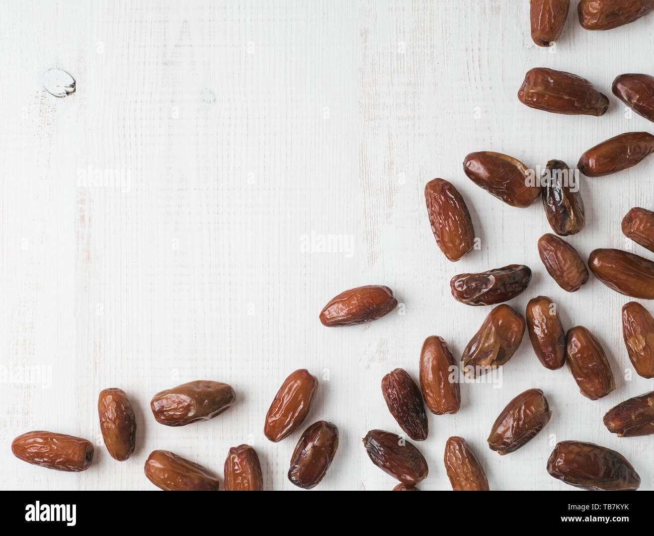 Dolce di datteri secchi su bianco sullo sfondo di legno. Datteri con copia spazio. Senza zucchero concetto alternative. Un'immagine di bordo con spazio per il testo. Vista superiore o flat-lay. Foto Stock