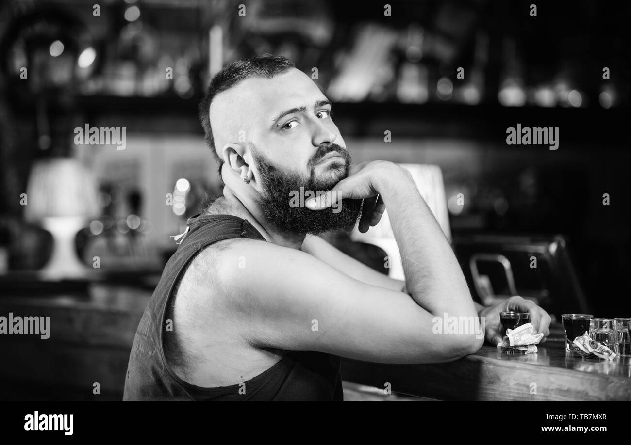 L' alcolismo e depressione. L'alcol addicted concetto. Tanga uomo brutale di bere alcol ordinare più bevande al banco bar. Guy trascorrere il tempo libero nel bar con alcolici. L'uomo ubriaco sedersi da solo nel pub. Foto Stock