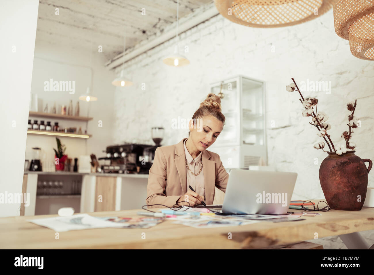 Concentrati sul lavoro. Bella smart designer nuovo disegno bozzetti seduto da solo al tavolo. Foto Stock