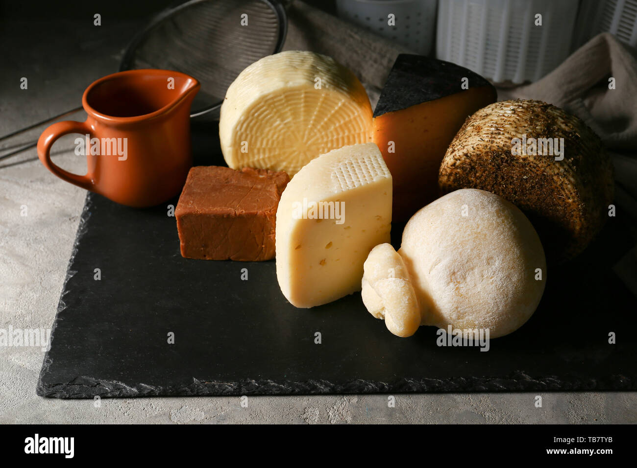 Assortimento di formaggi saporiti sulla piastra di ardesia Foto Stock