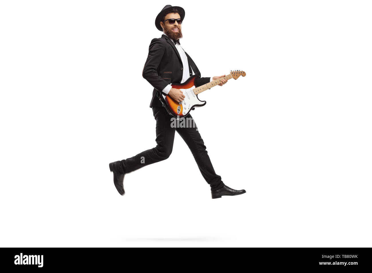 A piena lunghezza shot di un uomo di eseguire con una chitarra elettrica e saltando isolati su sfondo bianco Foto Stock