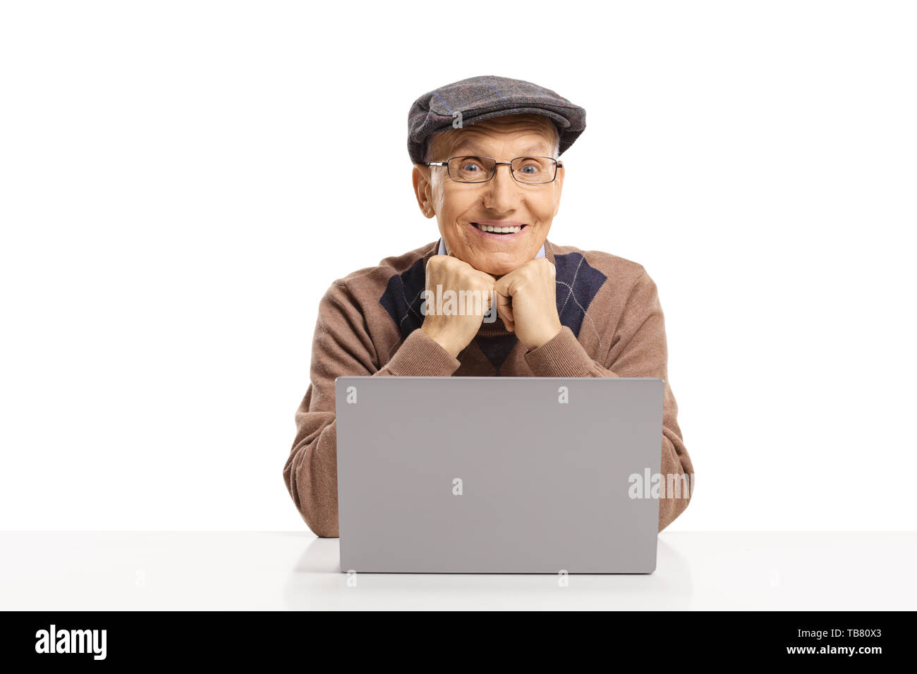 Allegro anziano uomo seduto con un computer portatile di fronte a lui isolato su sfondo bianco Foto Stock