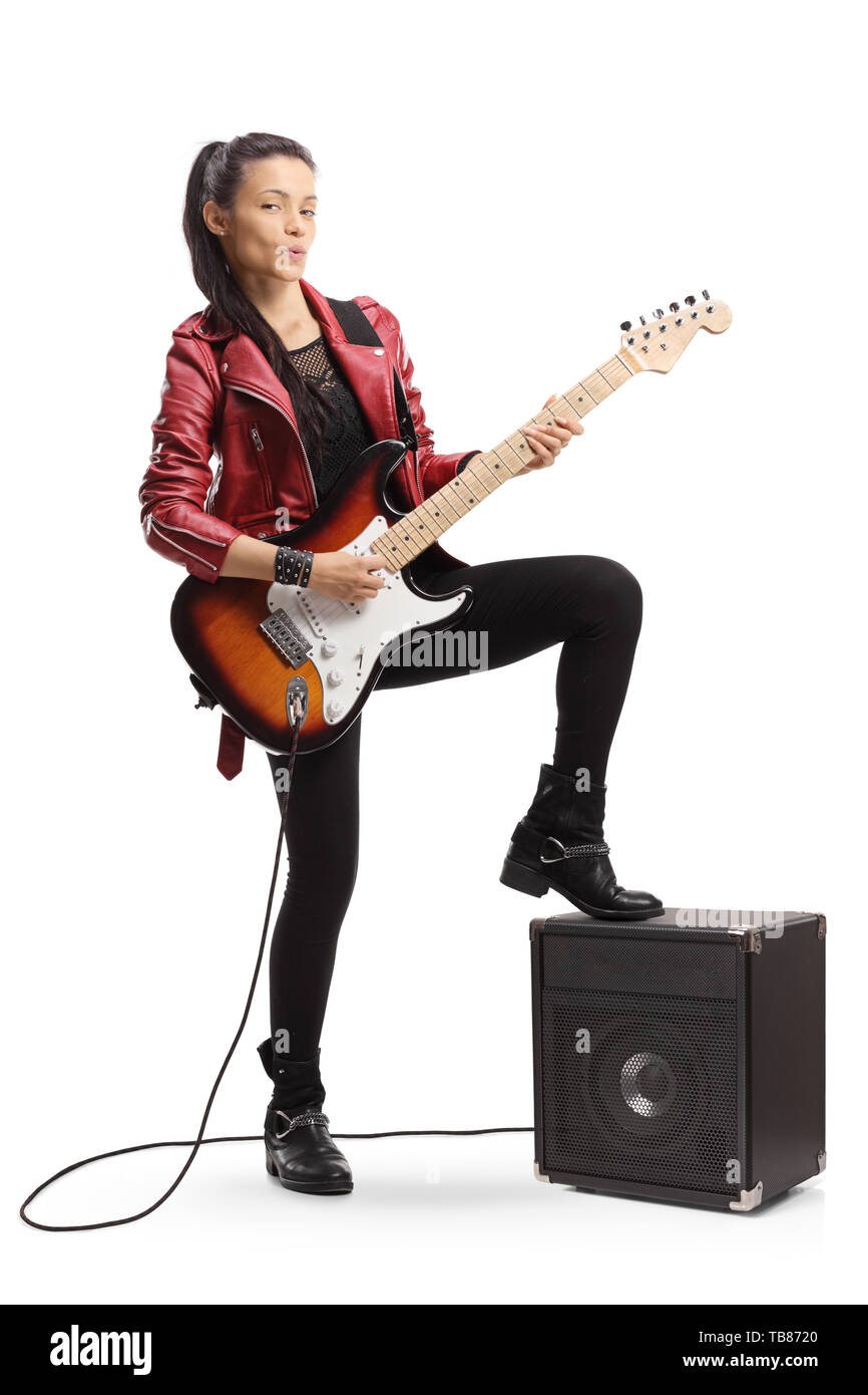 A piena lunghezza Ritratto di una giovane chitarrista femmina in piedi accanto a un amplificatore isolato su sfondo bianco Foto Stock