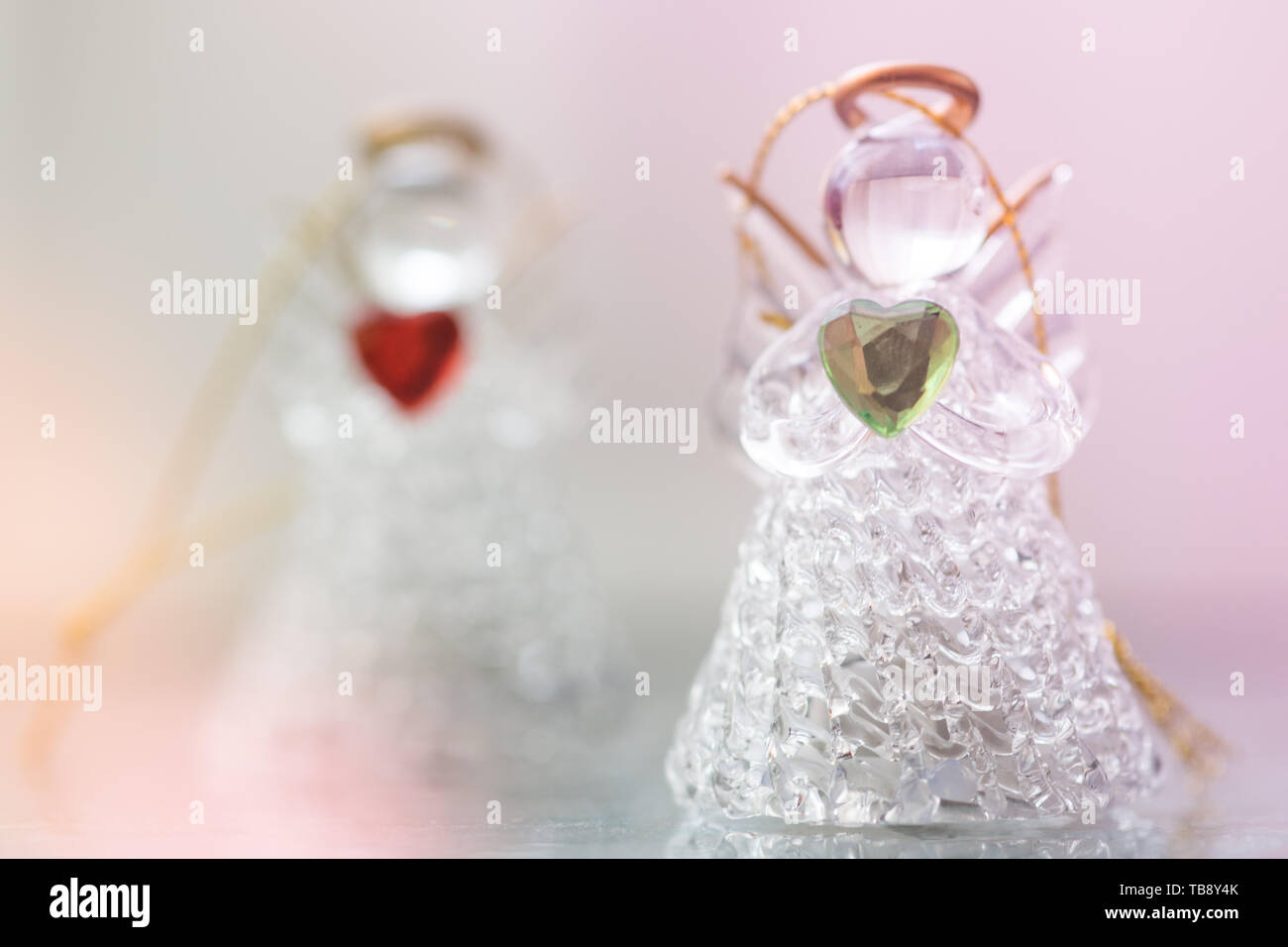 Due statuette di angelo di vetro con cuori nelle mani. Il concetto di pace e di amore. Foto Stock