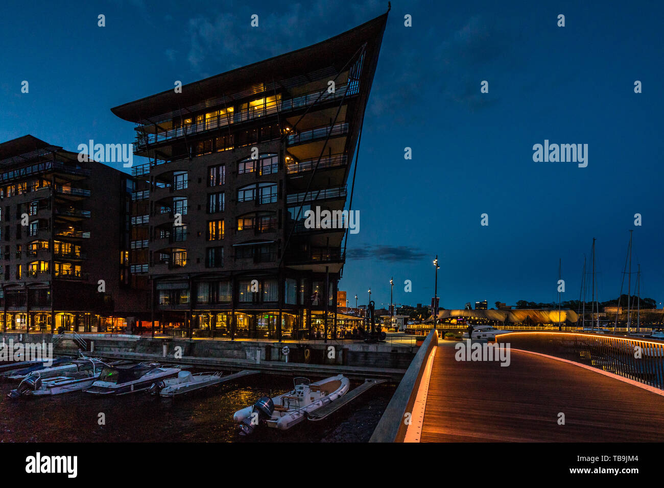 Twilight vista del ponte di collegamento Aker Brygge waterfront con Tjuvholmen quartiere, Oslo, Norvegia Foto Stock