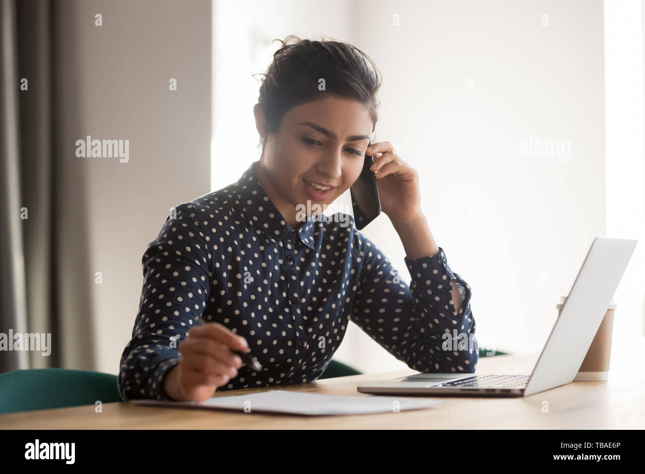 Occupato femmina dipendente indiano parlare sul cellulare al lavoro Foto Stock