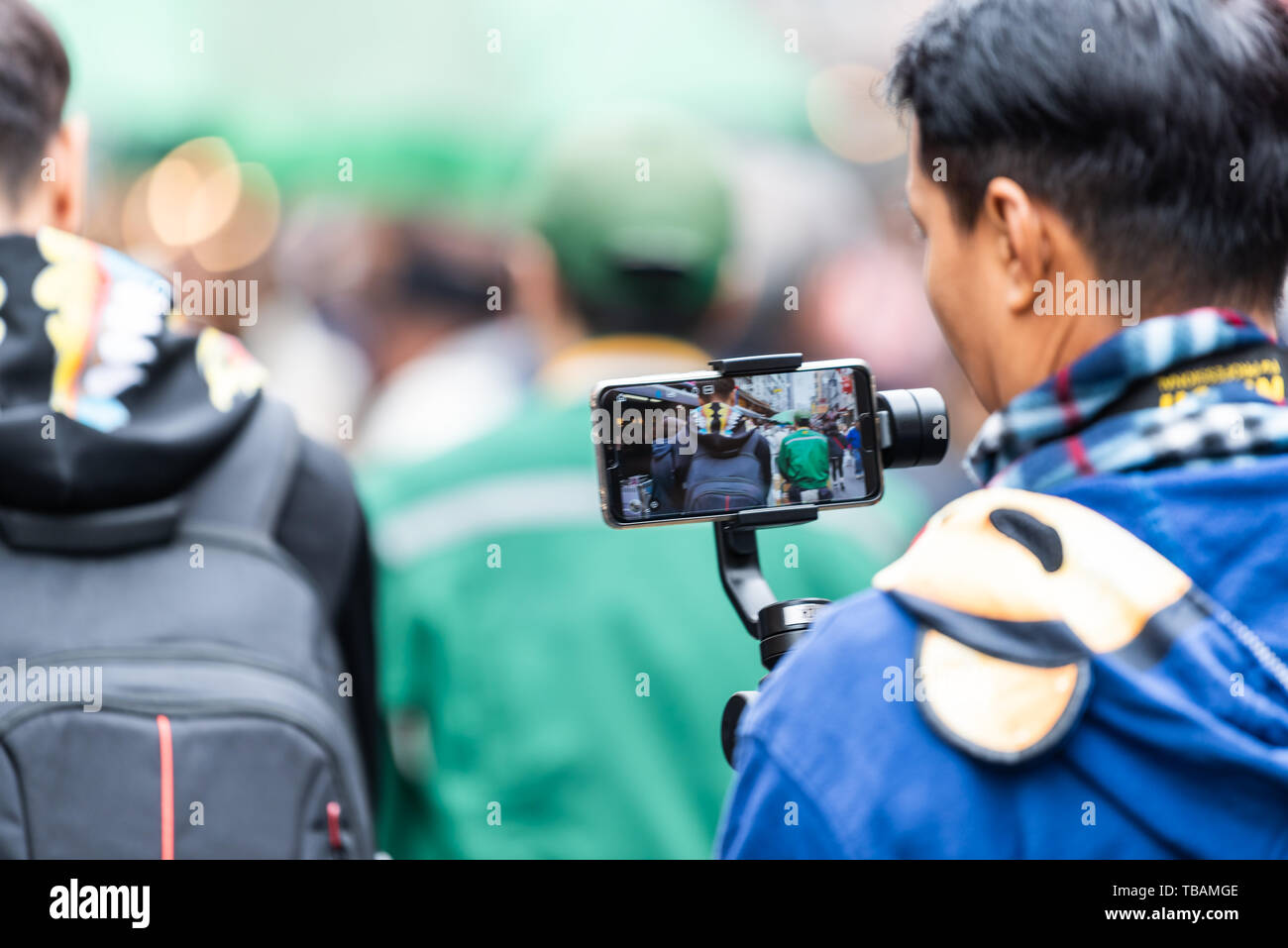 Tokyo, Giappone - 30 Marzo 2019: mercato esterno street di Tsukiji vicino a Ginza con uomo azienda telefono stabilizzatore di sospensione cardanica riprese video di persone Foto Stock