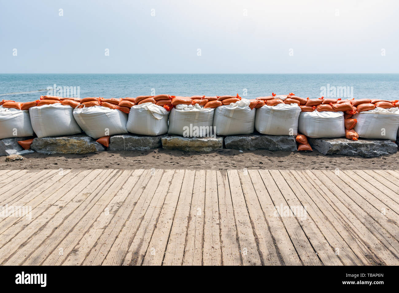 Plastica della protezione dalle inondazioni dei sacchi di sabbia impilati in una parete temporanea Foto Stock