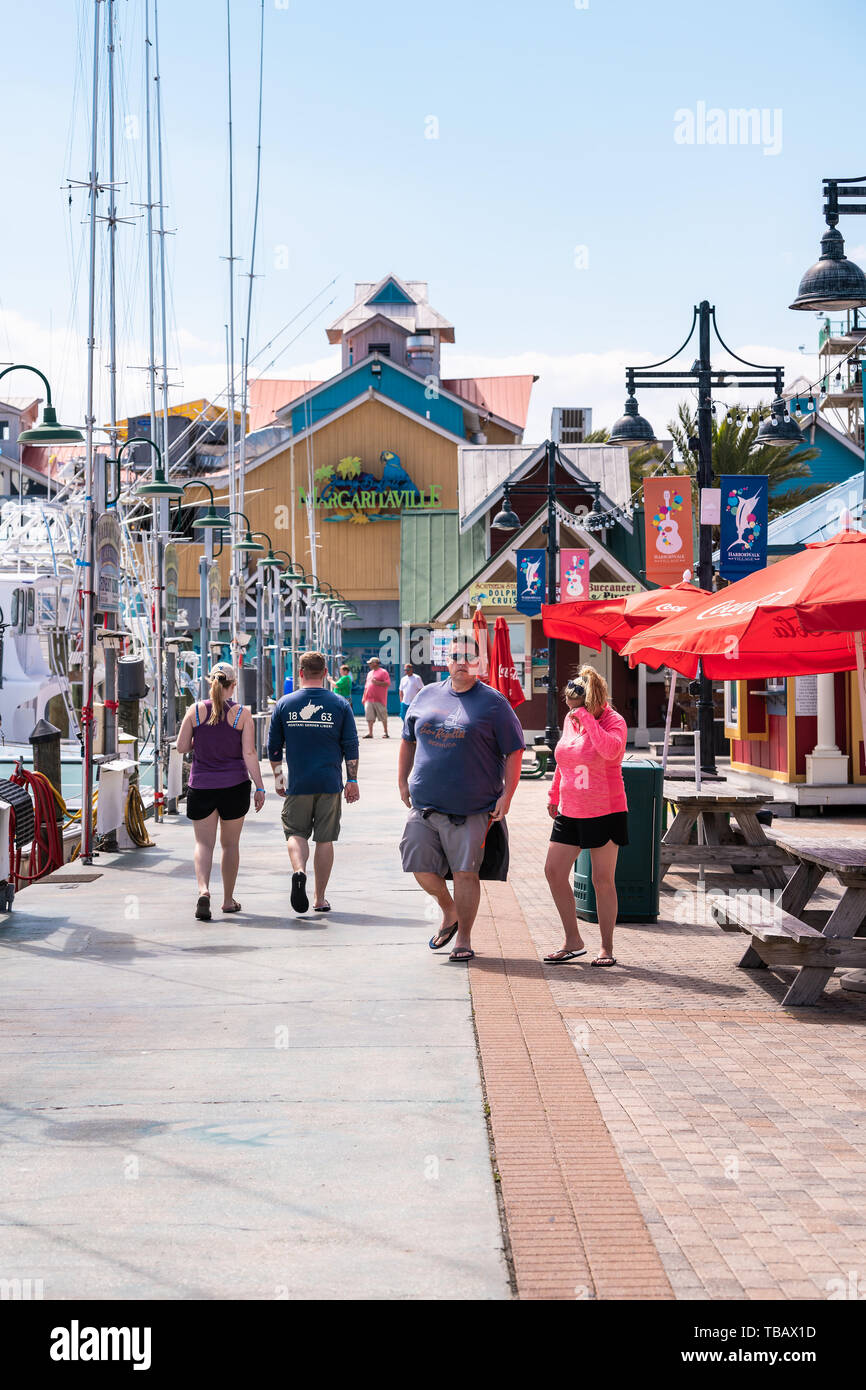 Destin, Stati Uniti d'America - 24 Aprile 2018: Harborwalk village con la gente a piedi dal porticciolo con il Margaritaville ristorante tropical bar cafe su estate giornata soleggiata in Foto Stock