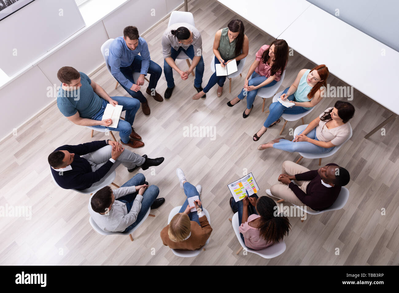 Elevato angolo di visione dei giovani e multirazziale amico millenario seduti in cerchio Counseling Foto Stock
