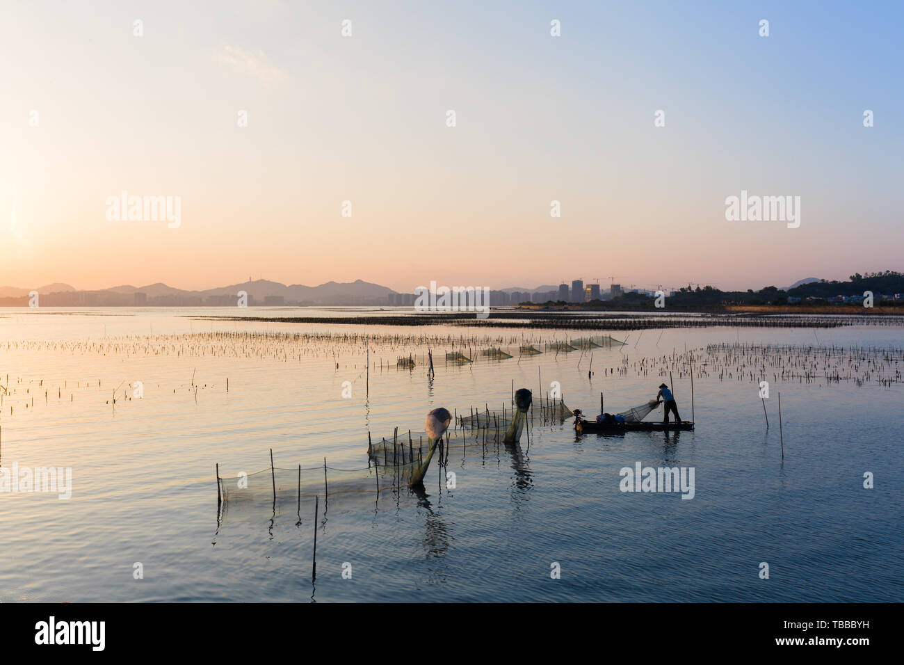 Il sole sta per cadere e i pescatori sono ancora al lavoro. Foto Stock