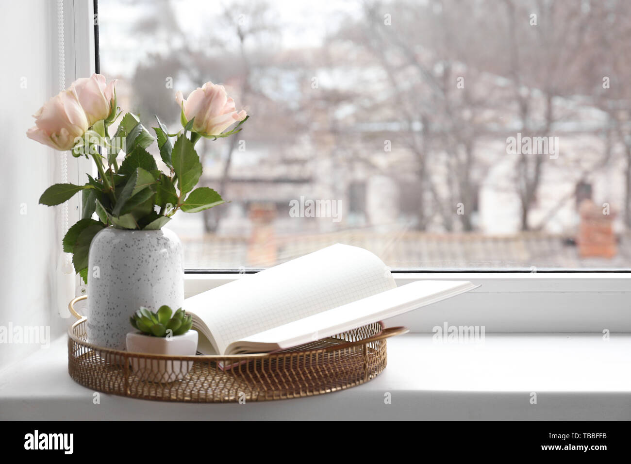 Vaso con bouquet di fiori e un libro sul davanzale Foto stock - Alamy