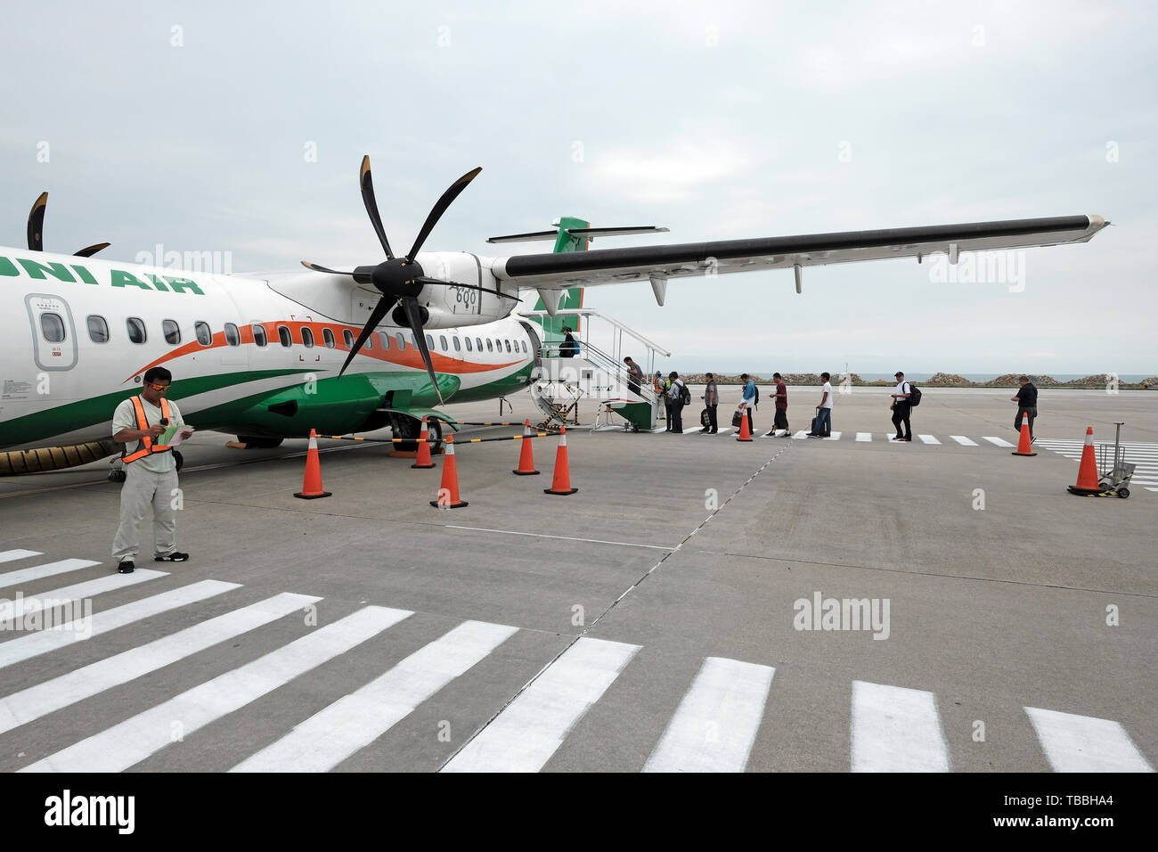 I passeggeri saliscono a bordo di un aereo turboelica a motore doppio ATR 72 dell'uni Air nell'Aeroporto Kinmen Shangyi situato nella cittadina di Jinhu dell'isola Kinmen. Taiwan Foto Stock