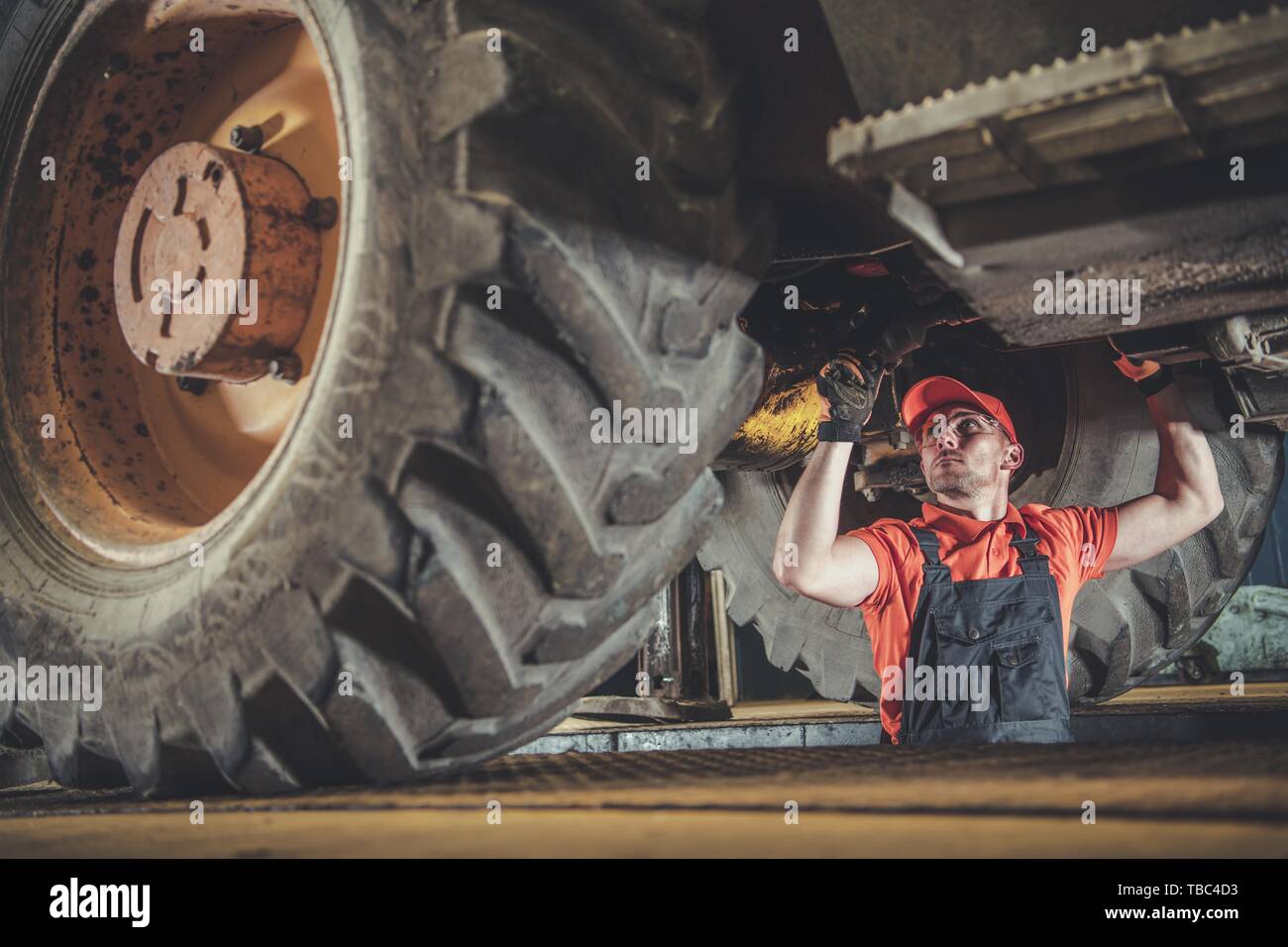 Macchinari pesanti meccanico. Tecnico caucasico sotto di medie dimensioni costruzione Bulldozer. Foto Stock