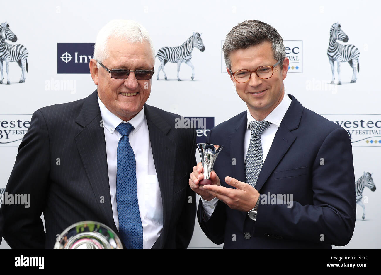 Trainer Roger Varian (centro) è presentato con il trofeo dopo la Investec incoronazione Cup durante il Signore giorno del 2019 Investec Derby Festival presso la Epsom Racecourse, Epsom. Foto Stock