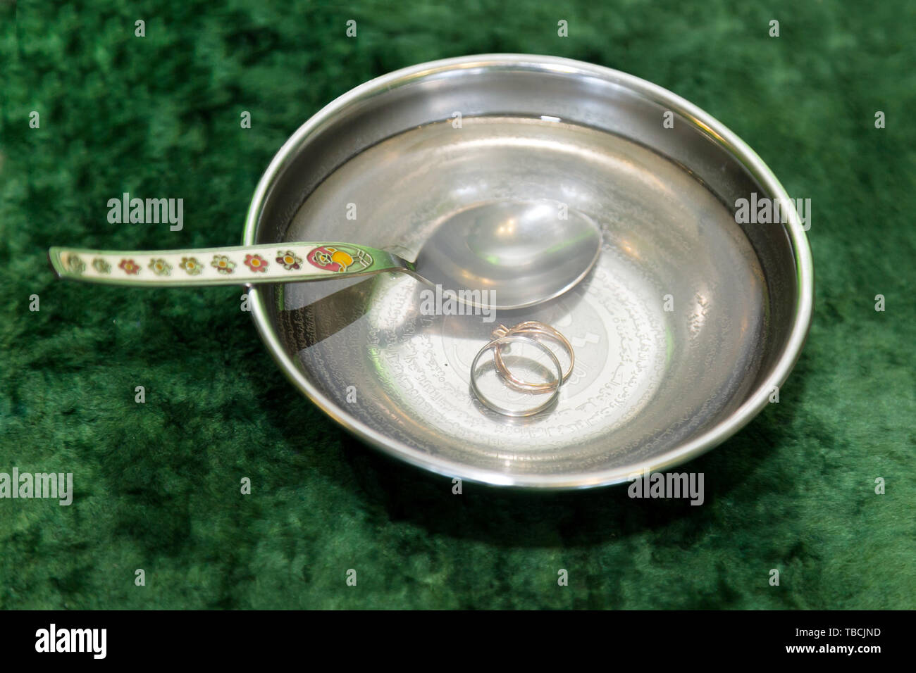 Gli anelli di nozze nella ciotola con acqua è un usanza islamica per la sacra Karan. Foto Stock