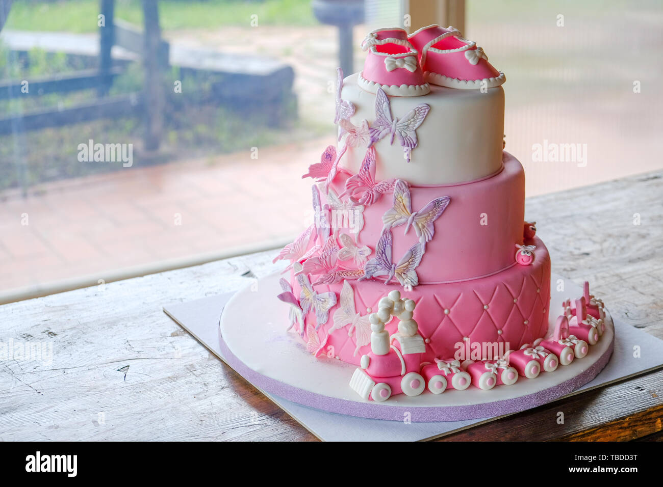 Torta di pugno per un po' di baby girl compleanno per celebrare il battesimo - rosa sugarpaste layered cake design n. persone Foto Stock