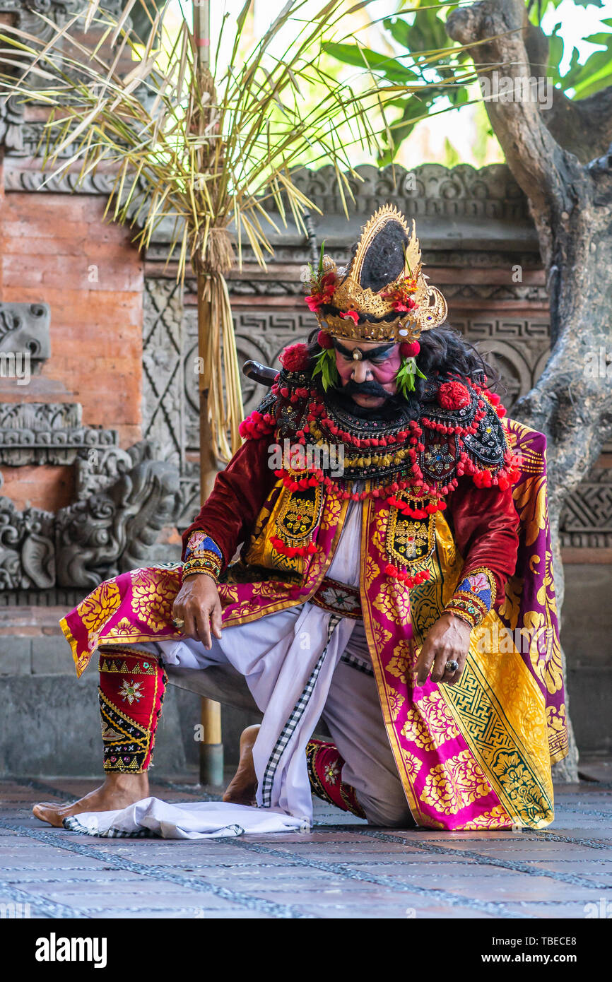 Banjar Gelulung, Bali, Indonesia - 26 Febbraio 2019: Mas villaggio. Riprodurre sul palco l'impostazione. Primo piano della sottomissione re inginocchiato in abito decorato di Foto Stock