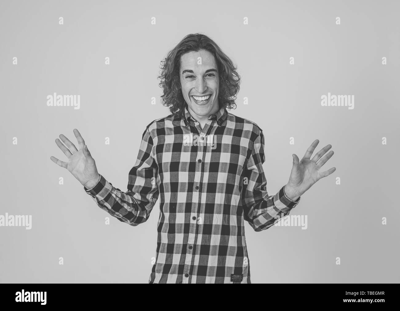 Ritratto di giovane adolescente felice l'uomo con divertenti esilaranti e facce di divertimento. La millenaria maschio con capelli lunghi rendendo silly divertente gesti ancora isolate Foto Stock