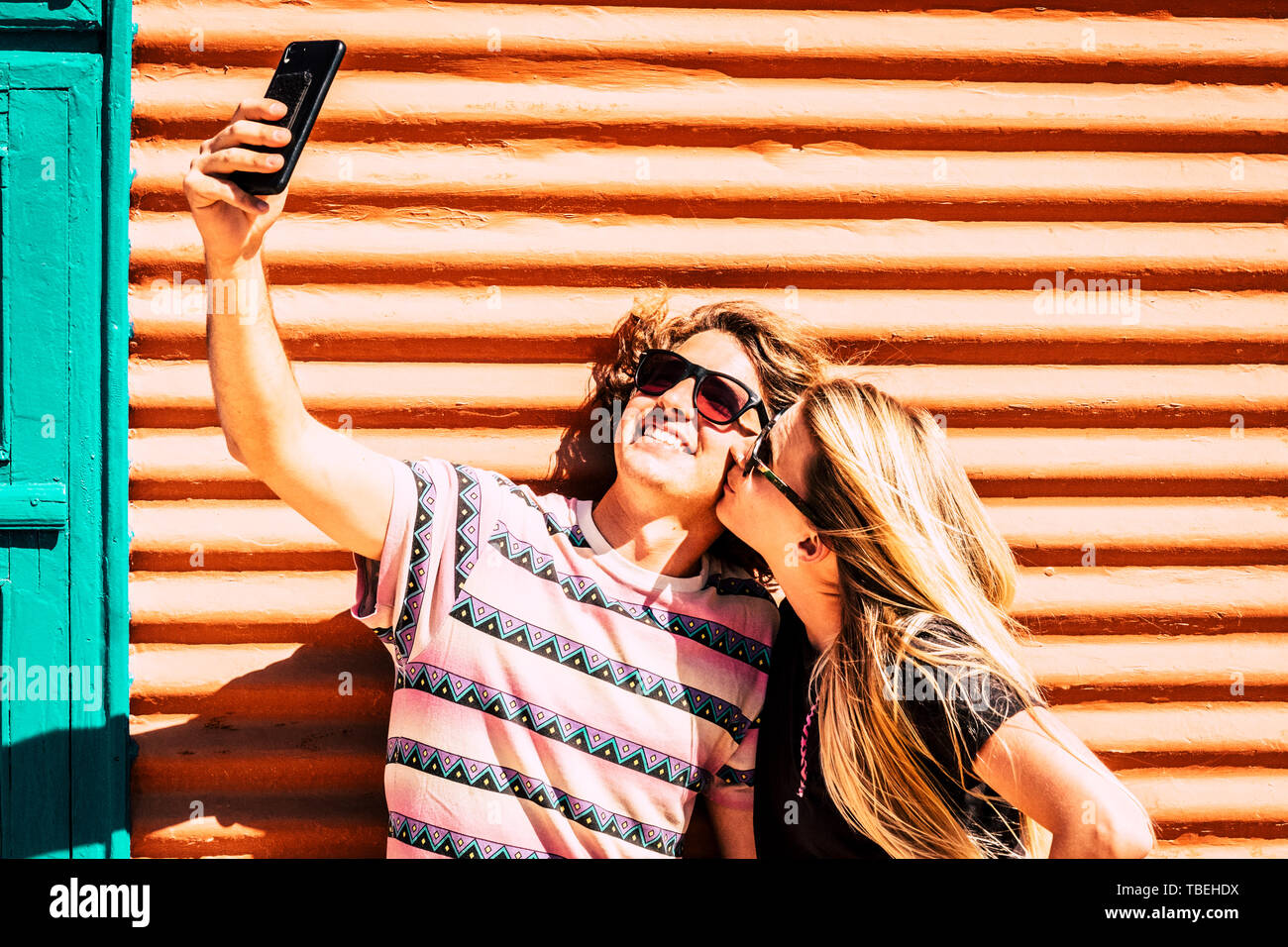 Amore e rapporti per i moderni giovani baciare e tenendo selfie foto con lo smartphone moderno - social media e daily post concetto per prett Foto Stock