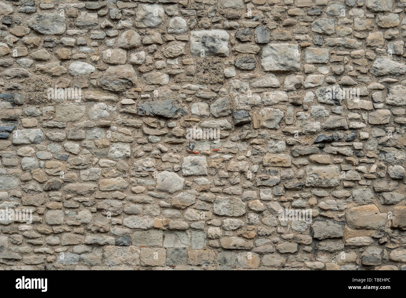 Modello di colore grigio di vecchio stile design decorativo incrinata irregolare pietra reale di una superficie di una parete in cemento. Beige vecchio muro di pietra texture di sfondo. Parte di Foto Stock