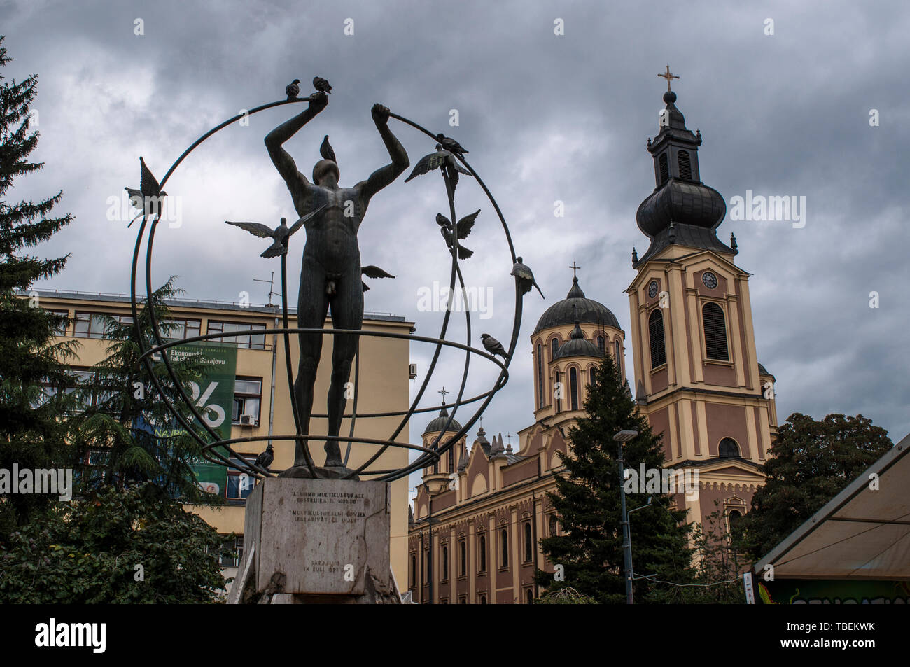 Sarajevo: multiculturale di uomo costruisce il mondo da Francesco Perilli in Trg Oslobodenja (liberazione piazza), la cattedrale della Natività della Theotokos Foto Stock