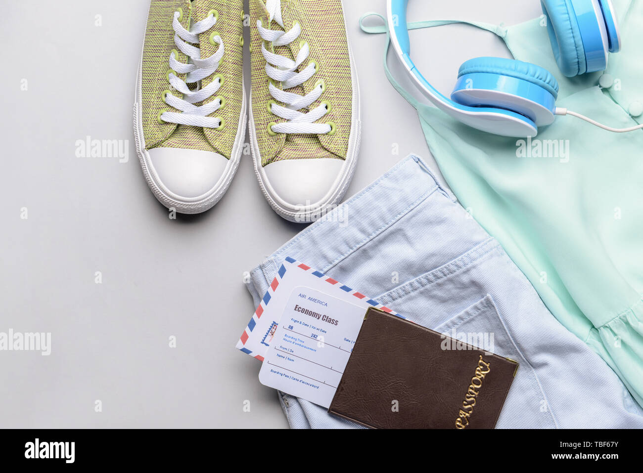 Abbigliamento femminile con documenti e cuffie su sfondo chiaro Foto Stock