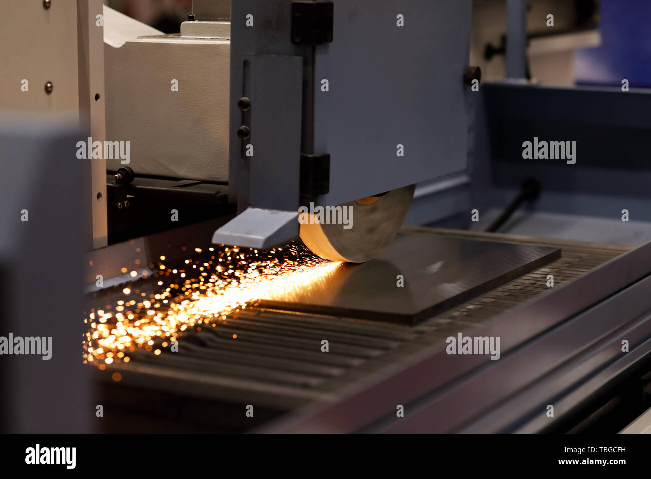 Piastra di metallo processo di smerigliatura sulla superficie industriale macchina rettificatrice. Messa a fuoco selettiva. Foto Stock