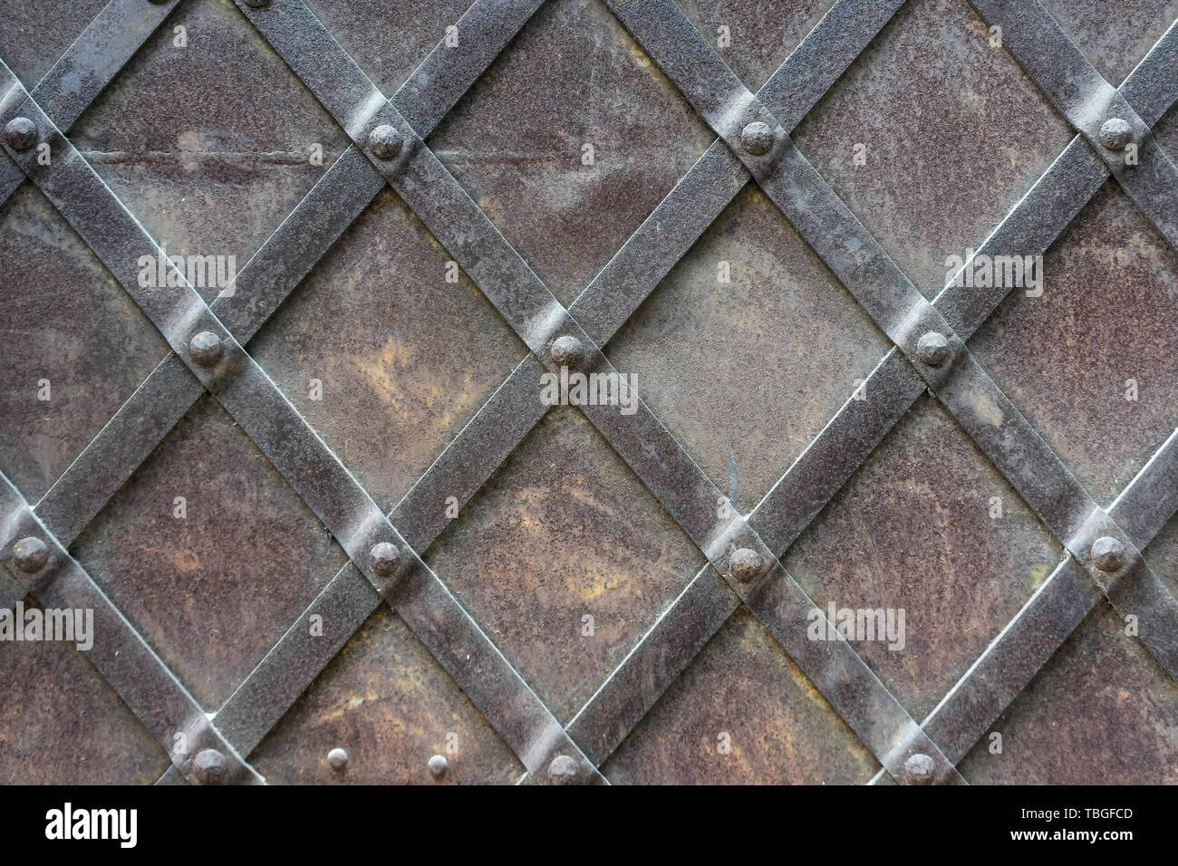 Frammento di una porta di metallo con strisce di ferro sui rivetti nella  città vecchia Foto stock - Alamy