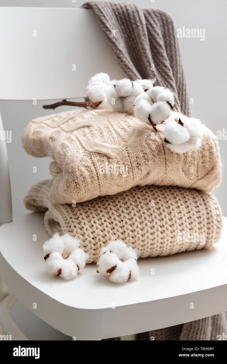Maglioni lavorati a maglia con fiori di cotone sulla sedia bianca Foto  stock - Alamy