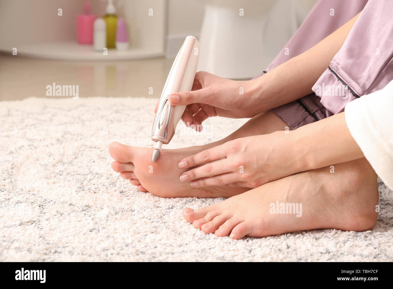 Giovane donna peeling piedi di lei a casa Foto stock - Alamy