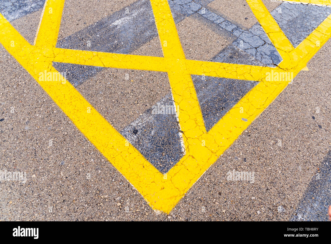 Luminose e di spessore delle linee di colore giallo sul pavimento di un parcheggio. Foto Stock