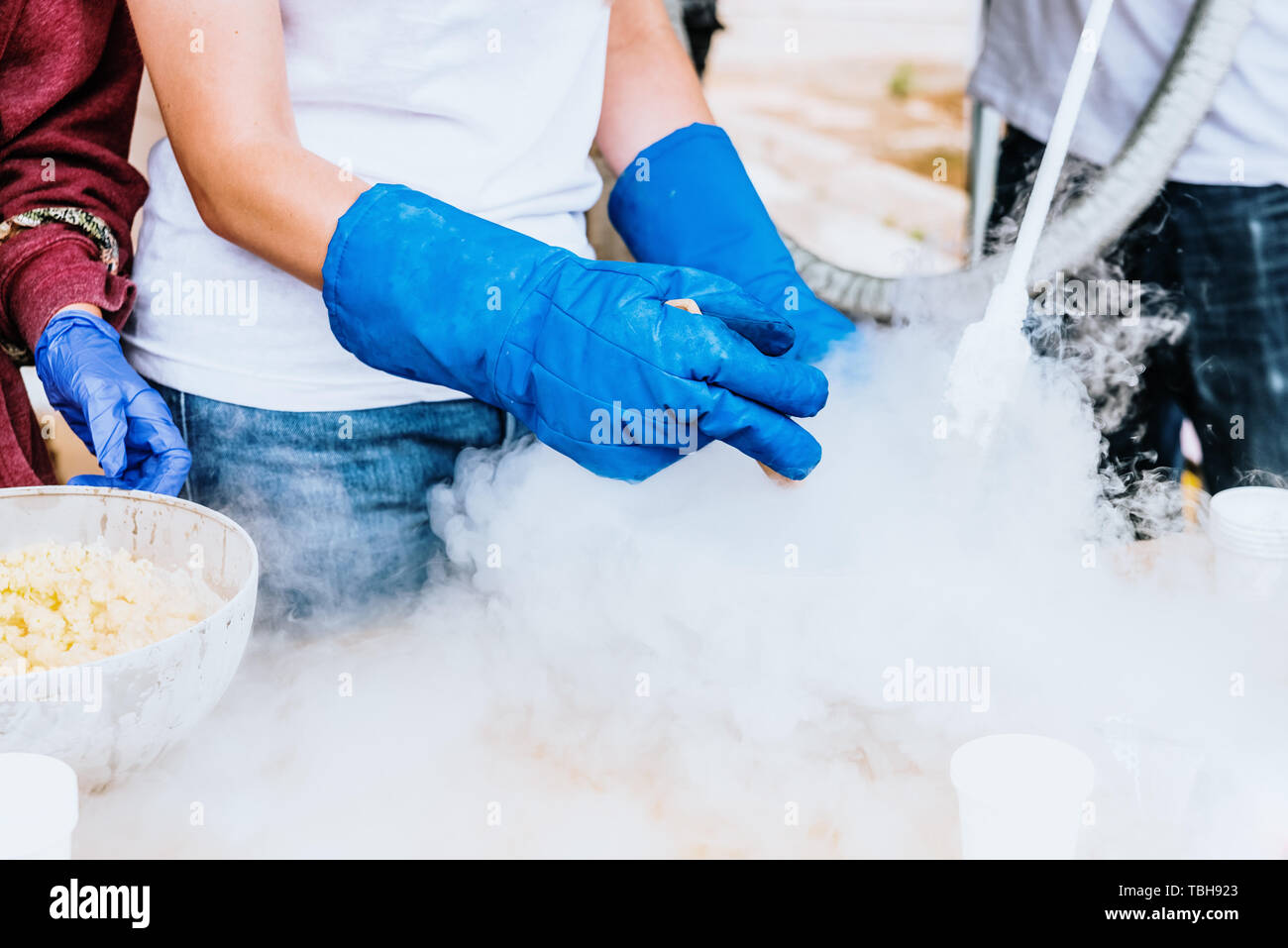 Versando azoto liquido con guanti di protezione. Foto Stock