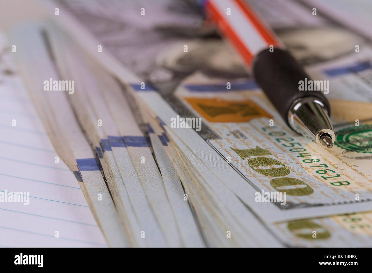 Un centinaio di dollari americani di banconote e penna che giace vicino fino Foto Stock