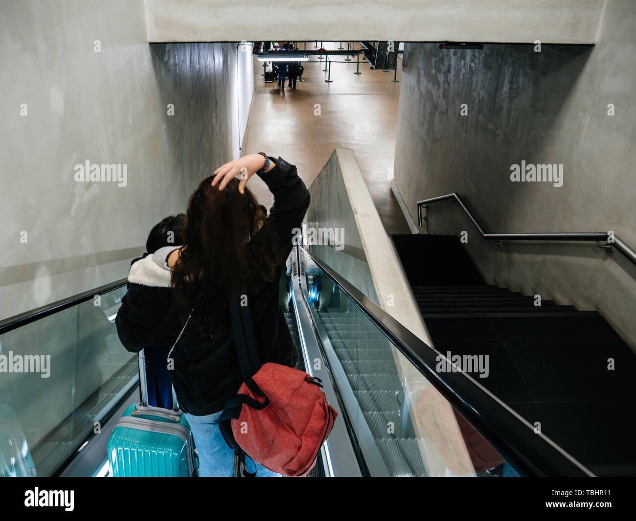 Lisbona, Portogallo - Feb 11, 2018: vista posteriore di un irriconoscibile i passeggeri scendono le scale sulla scala mobile per toccare airport terminal Foto Stock