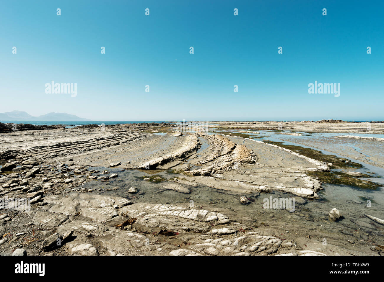 Vuoto spiaggia rocciosa in bluesky Foto Stock