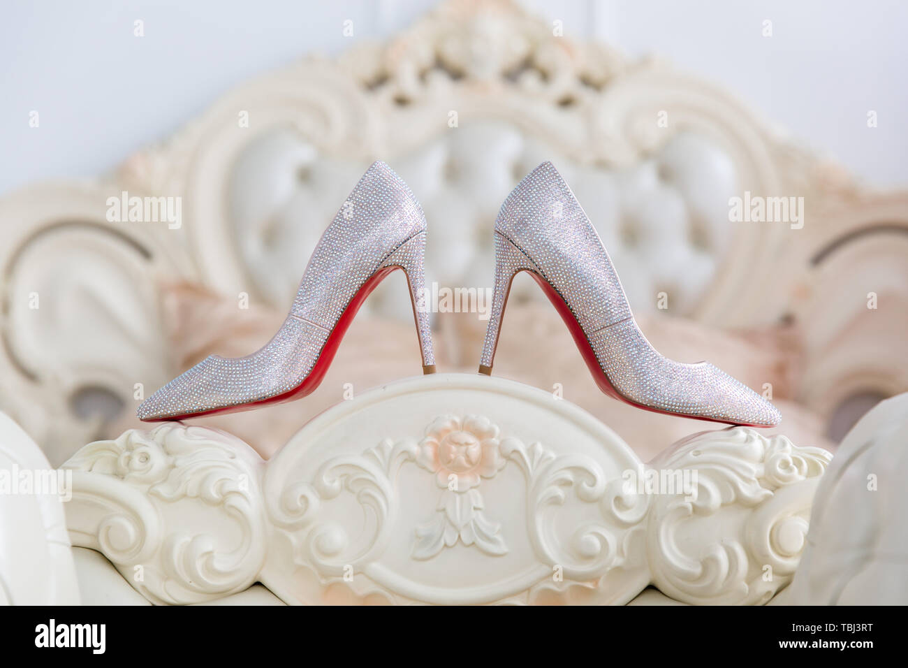 Scarpe bianche con un rosso suola ai piedi del letto, close-up Foto Stock