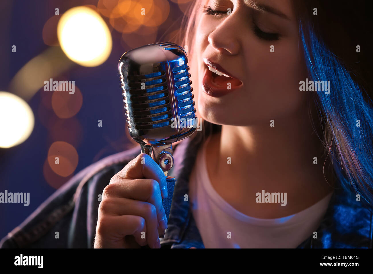 Bellissima cantante femminile con microfono sul palco, primo piano Foto Stock