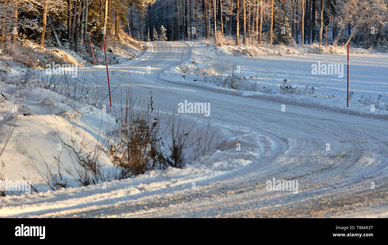 Strada in ghiaia curva lungo Långvreta, Bogesundslandet, Vaxholm, Svezia, in inverno Foto Stock