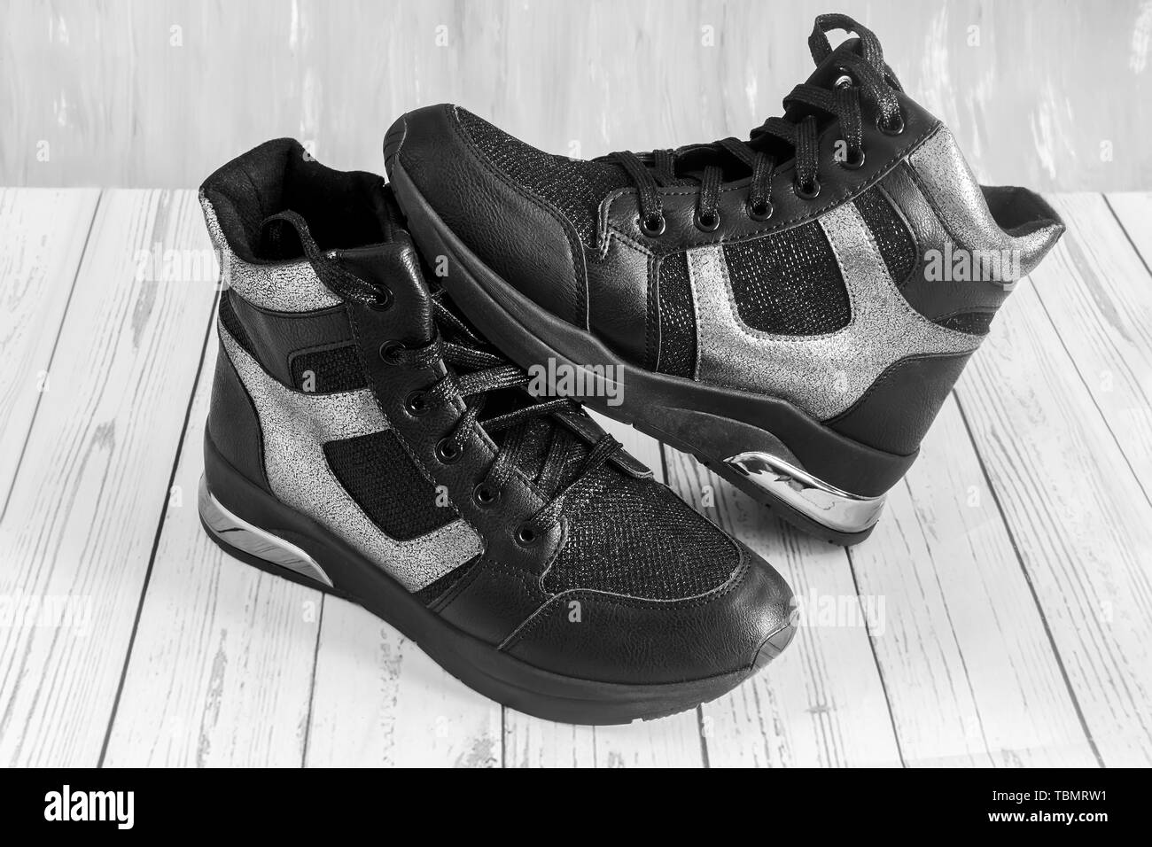 Confortevole sneakers nero con pannelli grigio su una piattaforma elevata con una cerniera lampo e lace-up. Immagine in bianco e nero Foto Stock